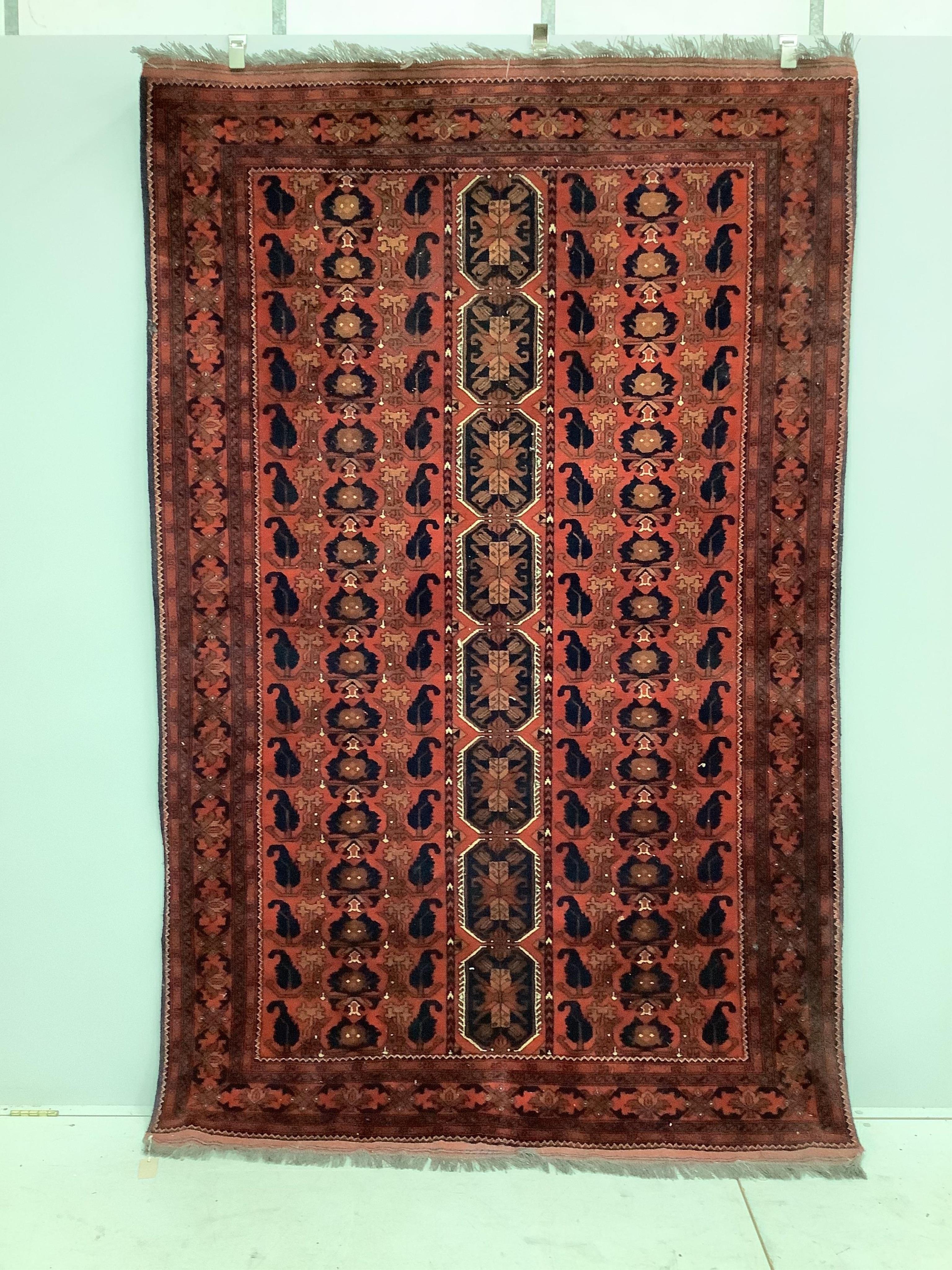A ‘Khan Mohamadi’ Afghan red ground rug, woven with rows of octagons and stylised devices, 240 x 156cm